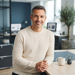 A professional portrait of Laurent Dubois smiling in a modern, softly lit office setting.